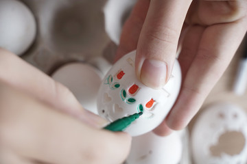 Drawing on Easter eggs using stencils. Children's art project. DIY concept. Step-by-step photo...