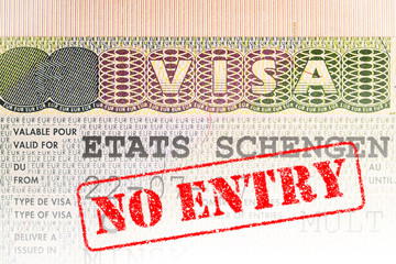Schengen visa in the passport with the seal “No Entry” on top. Digital montage.