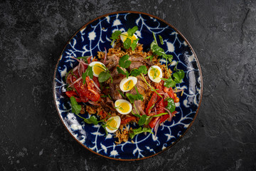 Food dish. Beans, rice, meat, salad, egg. Rustic wood background.