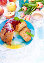 Pie with red icing on a light background and a bouquet of tulips. Spring breakfast.