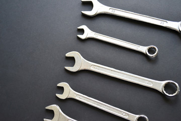 Steel wrenches on black background. Copy space