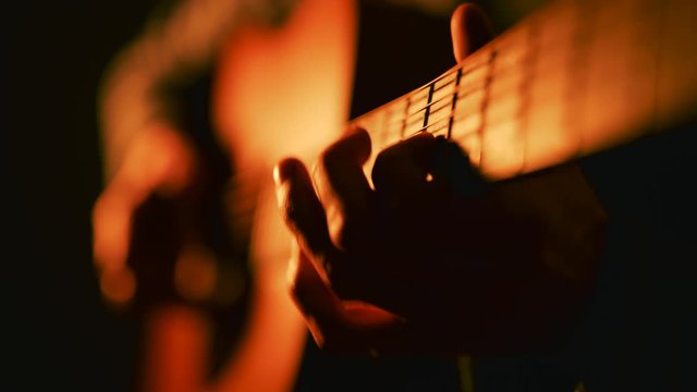 Solo acoustic guitarist playing guitar - close up of hands on fretboard