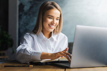 Young female working on successful project. Motivated specialist executing tasks efficiently in...