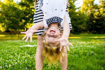 Obraz premium mother fooling around with his little daughter in park