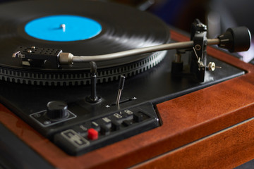 Close-up of blue music record on turntable, turntable needle playing music, selective focus