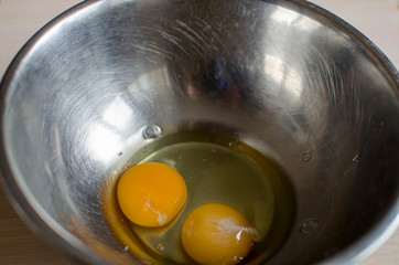 two broken eggs in a whisk bowl. making breakfast. ingredient for pancakes, cream, cakes