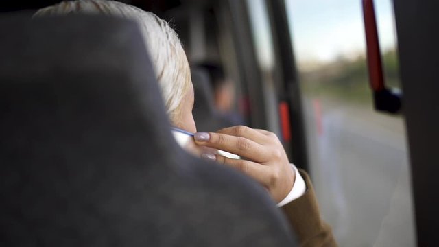 young woman using a phone on a bus