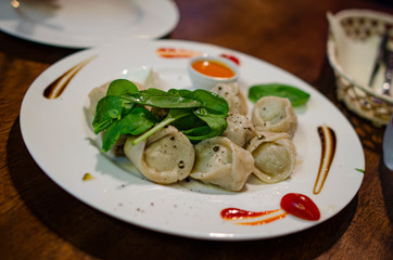 DISH WITH SMALL DUMPLINGS AND SPINACH LEAVES 