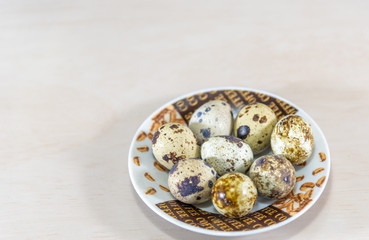 Quail eggs arranged in a porcelain saucer on a neutral background