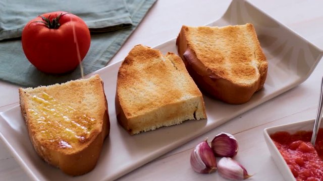 Mediterranean breakfast, pouring olive oil on a toasted bread