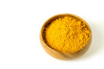 Turmeric powder in wooden bowl on the white background isolated closeup. Alternative medicine, healing spice, health care concept.