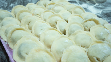 Fototapeta na wymiar Meat dumplings - russian pelmeni on wooden background