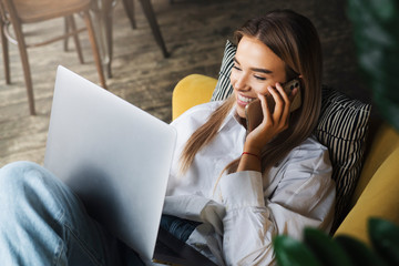 Young woman relaxing at home, watching movies on laptop, streaming tv series, talking to friends on...