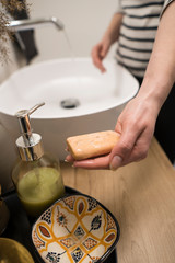 COVID-19 Coronavirus. Woman washing hands with foam soap and hot water at bathroom. Hygiene, preventing coronavirus. Corona Virus pandemic protection by cleaning hands frequently.