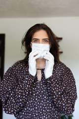 portrait of beautiful young woman wearing cotton white mask and medical/surgical gloves on white background. 