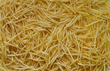 Thin little noodles, a kind of Italian pasta as a food background or texture.