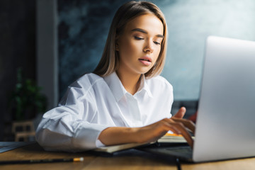 Young female working on successful project. Motivated specialist executing tasks efficiently in...