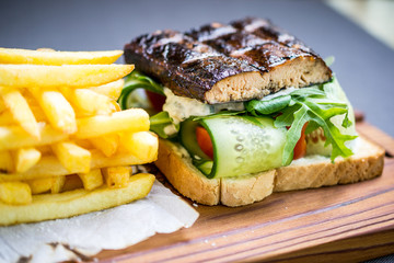 Grilled fish sandwich with cucumbers, tomatoes