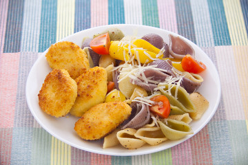 tasty appetizing pasta with chicken nuggets on white plate