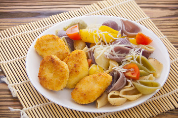 tasty appetizing pasta with chicken nuggets on white plate