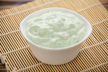 Tasty fresh grained cottage cheese on a plate on  wooden table