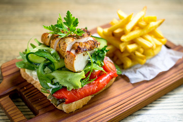 Grilled chicken breast on a toast with tomatoes