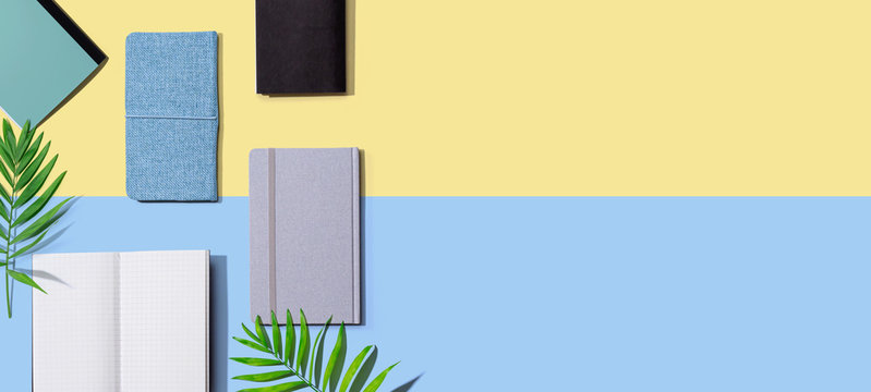 Collection of notebooks with tropical leaves - flat lay