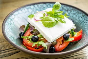 Salad with goat feta cheese, tomatoes, olives