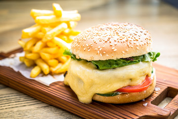 Fresh cheeseburger with melting cheese, tomatoes