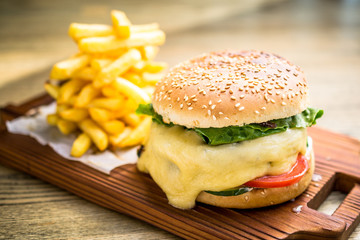 Fresh cheeseburger with melting cheese, tomatoes