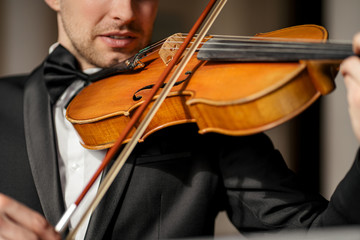 young talented professional man gracefully play violin, handsome musician in formal elegant suit perform classic music