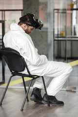 Coronavirus pandemic. Tired, stressed and exhausted doctoror or desinfector specialist after long shift fighting against Coronavirus at hospital clinic. Global pandemic outbreak worldwide virus.