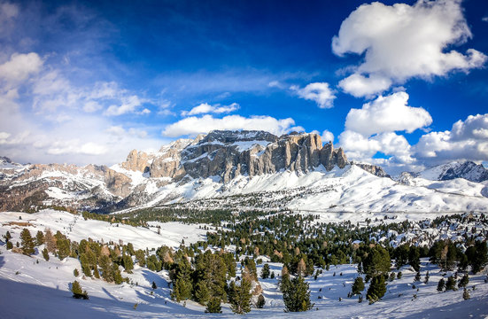 Landscape at a ski resort Campitello di Fassa Italy. Winter Dolomites and blue sky with clouds.