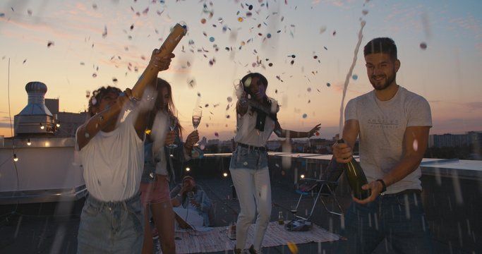 Young Man Opening Bottle Of Champagne