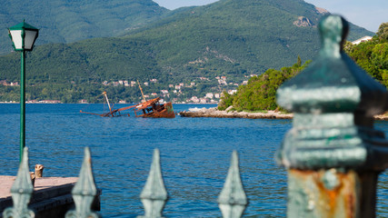 View over the fence at sunken ship near the Rose Village, peninsula of Lustica, Kotor Bay,...