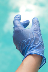 Imagen de la mano de un sanitario con guantes protectores  azules contra la pandemia y fondo de...
