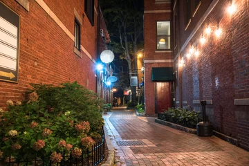Fototapete Enge Gasse Schmale Gasse zwischen alten Backsteingebäuden mit Geschäften und Restaurants im Erdgeschoss in der Nacht