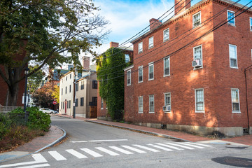 Empty street lined with brick and wooden buildings in a downtown on a clear autumn day