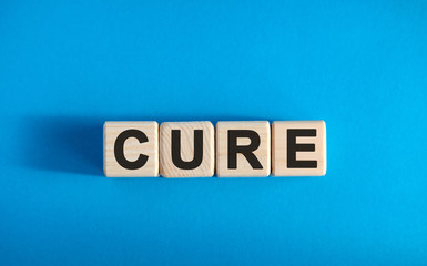 CURE - text on wooden blocks, medical concept, blue background