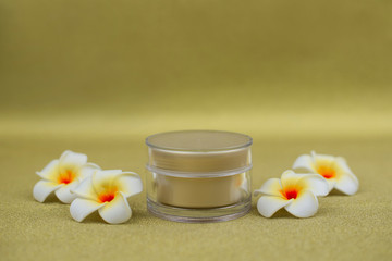 Fototapeta na wymiar face cream in a jar cosmetic for skin with mango flowers