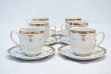 Mock up / design set of elegant and traditional teapot colorful white blue gold coffee cup & Tea cup on cup's plate beside the hot tea pot , design/ drink-ware isolated on white background