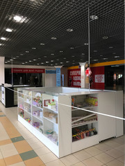 Kharkov, Ukraine, 11th april 2020:
quarantined empty stores in the mall, tied with a white and red boundary tape, during the quarantine, wide shot