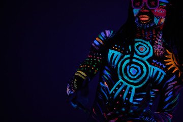 funny cool fashion dancer in fluorescent body art, african man move in dark neon space, fluorescence and luminescence concept