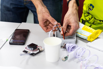 Assembling the weather sensor. Small electronics are assembled and sewn at the table. Public monitoring of air pollution.