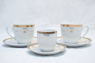 Mock up / design set of elegant and traditional teapot colorful white blue gold coffee cup & Tea cup on cup's plate beside the hot tea pot , design/ drink-ware isolated on white background