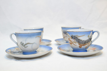 Mock up / design set of elegant and traditional teapot colorful white blue gold coffee cup & Tea cup on cup's plate beside the hot tea pot , design/ drink-ware isolated on white background