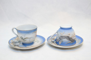 Mock up / design set of elegant and traditional teapot colorful white blue gold coffee cup & Tea cup on cup's plate beside the hot tea pot , design/ drink-ware isolated on white background