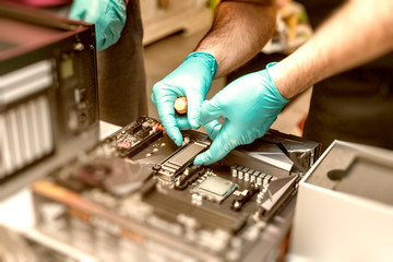 Personal computer technicians mounting ssd drive on the motherboard socket, pc assembling