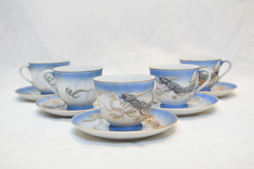 Mock up / design set of elegant and traditional teapot colorful white blue gold coffee cup & Tea cup on cup's plate beside the hot tea pot , design/ drink-ware isolated on white background