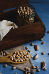 Raw chickpeas in a glass jar and wood spoon.
